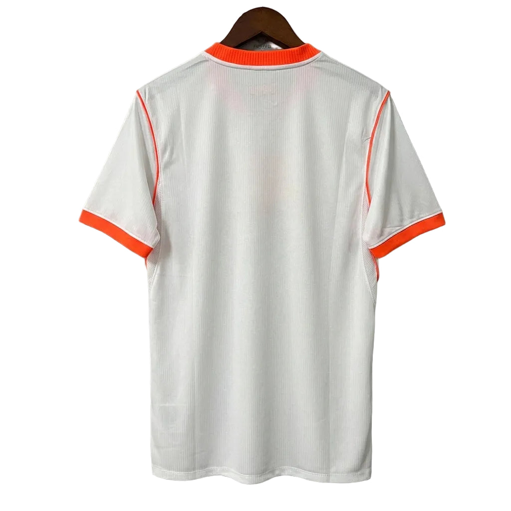 White shirt with orange trim on a hanger against a gray background