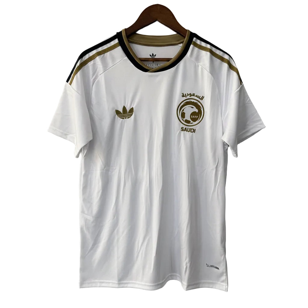 White t-shirt with Adidas logo and Saudi Arabia emblem on a hanger against a gray background