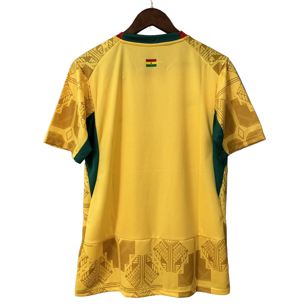 Yellow sports jersey with green accents on a hanger against a gray background