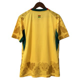 Yellow sports jersey with green accents on a hanger against a gray background