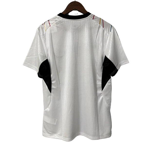 White t-shirt with black and colorful accents on a hanger against a gray background
