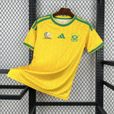 Yellow sports jersey with green accents on a hanger against a metal grid background